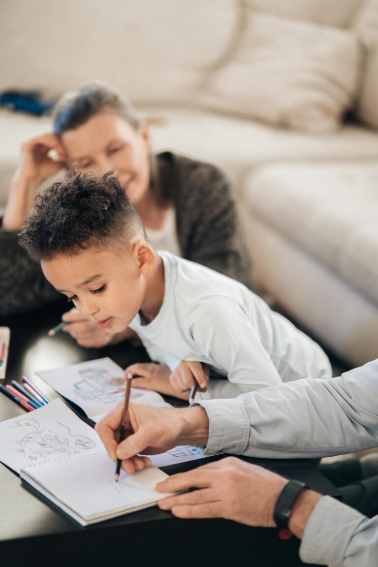 A child and older family members enjoying drawing together in a cozy living room.
