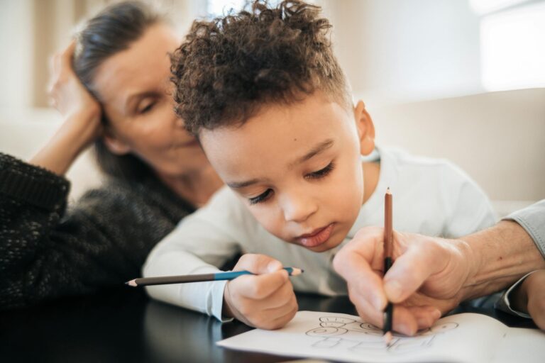 A touching moment between a grandmother and her grandson as they color together, fostering creativity and connection.